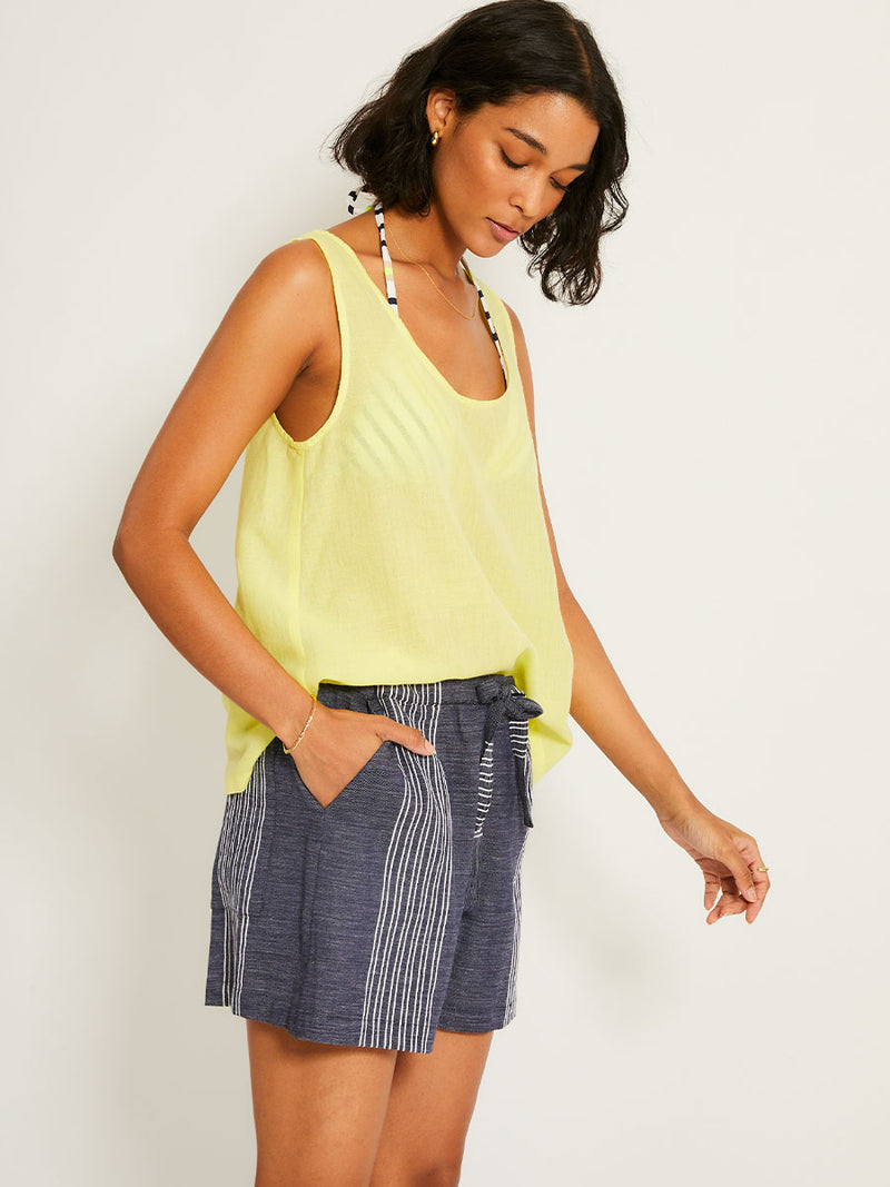 Woman Standing Wearing lemlem SAFIA Shorts  featuring chambray navy color accented with fine, textured white stripes
